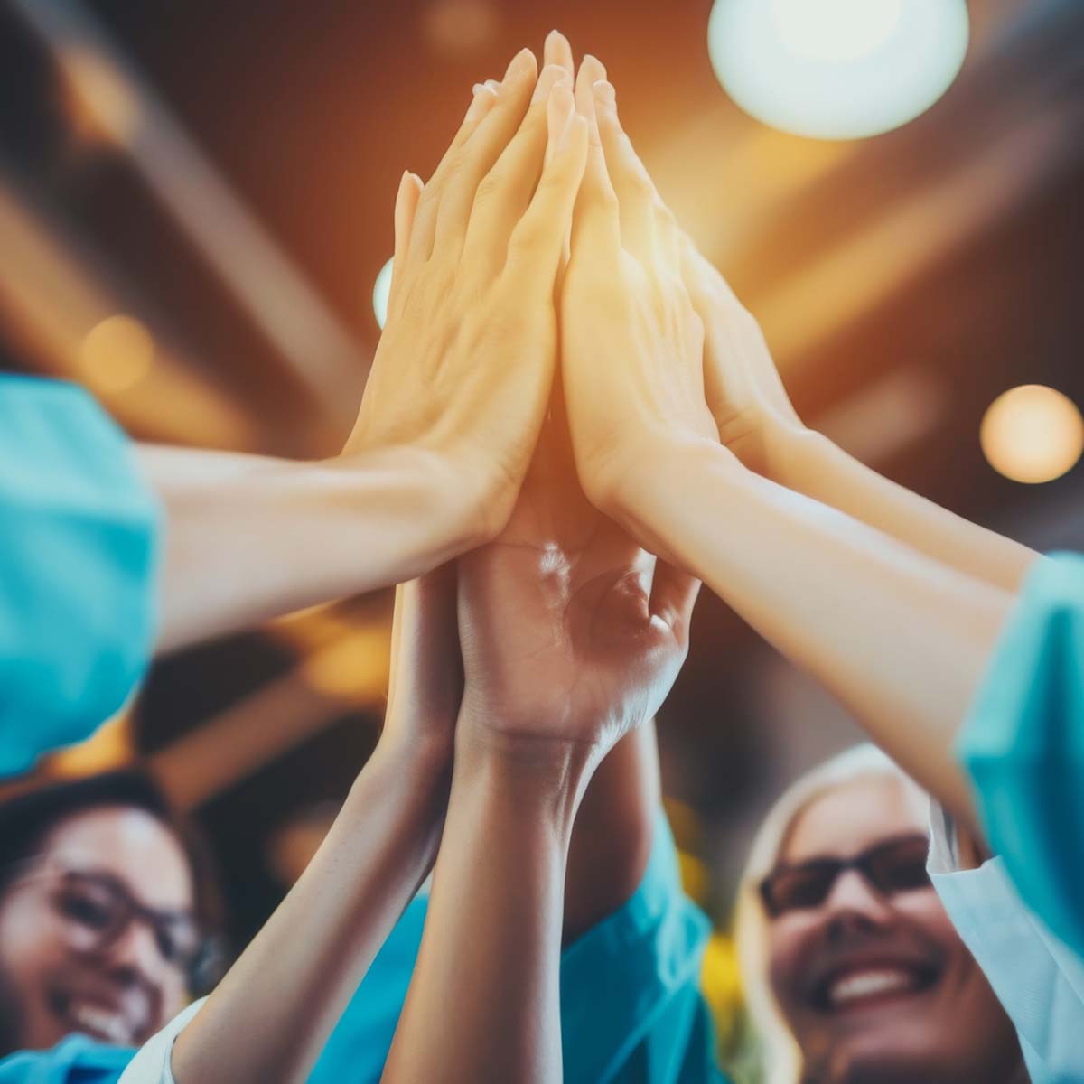 Mehrere Mitarbeiter machen ein High-Five, um die Nachhaltigkeit in Ihrem Unternehmen zu feiern.