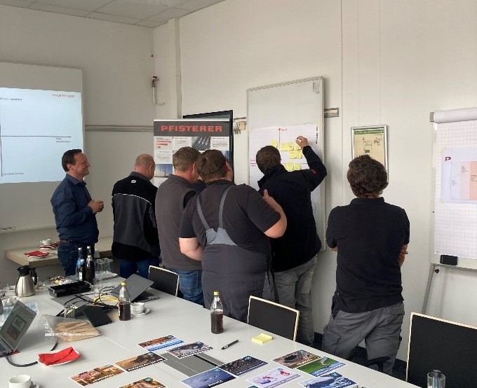 Mitarbeiter schreiben etwas auf Whiteboard.