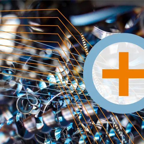 Lupe mit KEFF+Symbol mit Metallspänen im Hintergrund als Symbol für Nachhaltigkeit im Unternehmen.